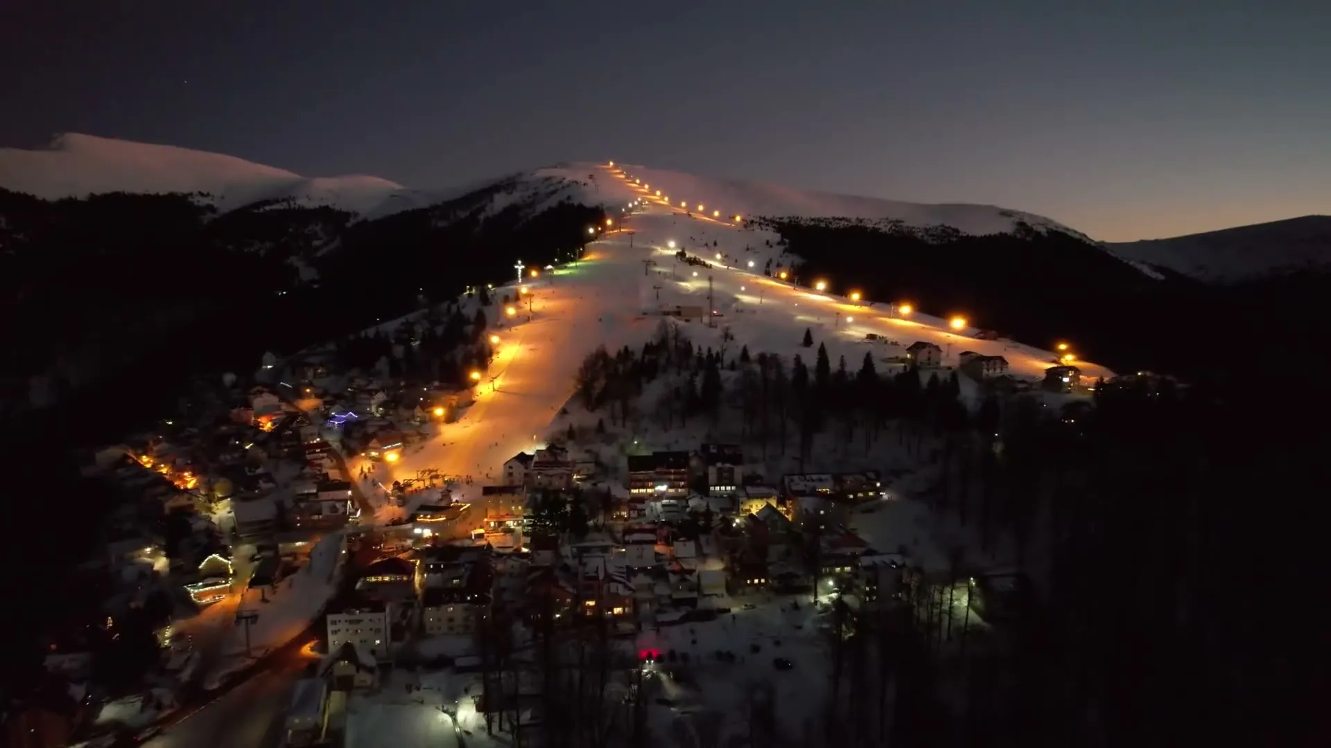 Floodlit slopes above the resort in the evening